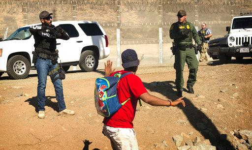 A Central American migrant is stopped by U.S. agents who order him to go back to the Mexican side of the border, after a group of migrants got past Mexican police at the Chaparral crossing in Tijuana, Mexico, Sunday, Nov. 25, 2018, at the border with San Ysidro, California. The mayor of Tijuana has declared a humanitarian crisis in his border city and says that he has asked the United Nations for aid to deal with the approximately 5,000 Central American migrants who have arrived in the city. [Photo: AP/Pedro Acosta]