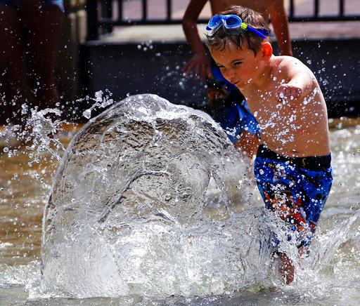 After a morning in kindergarten, Luke Miedel, 5, spends the afternoon in 90 degree heat playing in a fountain on the Northside of Pittsburgh Wednesday, Aug. 29, 2018. [Photo: AP/Gene J. Puskar]