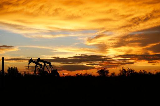 FILE- In this June 5, 2017, file photo pumpjacks work in an oil field at sunset after a thunderstorm passed through the area in Karnes City, Texas. The United States may have reclaimed the title of the world's biggest oil producer sooner than expected. The U.S. Energy Information Administration said Wednesday that America