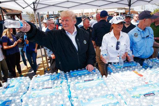 President Donald Trump and first lady Melania Trump hand out water during a visit to areas affected by Hurricane Michael, Monday, Oct. 15, 2018, in Lynn Haven, Fla. Florida Gov. Rick Scott is at right. [Photo: AP/Evan Vucci]